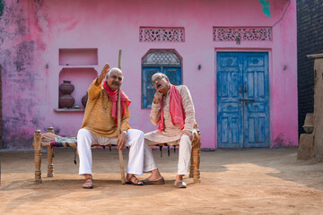 Two old indian villagers talking out of home