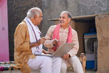 Two indian old man using laptop at out of home - obrazy, fototapety, plakaty