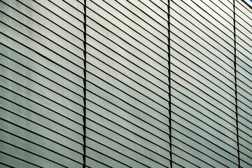 Detail or texture shot side of building facade and slatted wood pannels on exterior of black gray building in the downtown city