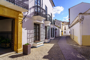 Picturesque narrow alley with white houses and barred windows in Ronda, Andalucia.