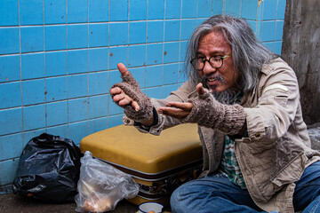 Homeless old man reaching out to passerby ask for money, need for help, Poverty man no home meet...