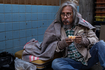 Homeless poverty man meet financial crisis sitting on street and eating bread, aged man crazy no...