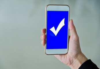 Closeup of hand holding smartphone with vote button on the screen