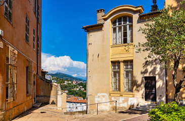 Historic medieval clock tower and tenement houses at Place du 24 Aout square in old town quarter of perfumery city of Grasse in France