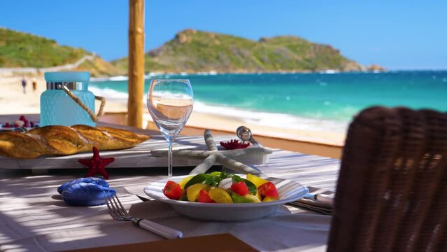 Une magnifique table estivale dress&eacute;e dans une paillote  au bord d' une plage de r&ecirc;ve de m&eacute;diterran&eacute;e , on devine au loin le Cap Taillat .