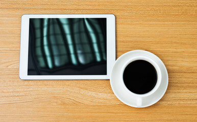 Fototapeta na wymiar Top view of digital tablet and coffee cup on wooden table