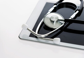 Stethoscope and digital tablet on white background