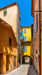 Fototapeta na wymiar Narrow streets and historic houses of old town quarter with Rue du Poilu street in Villefranche-sur-Mer resort town in France