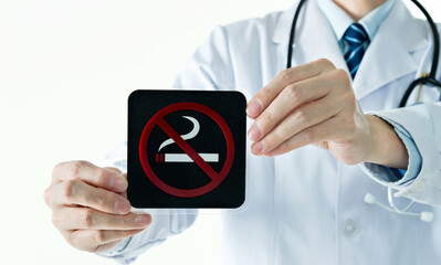 Doctor holding no smoking sign against white background