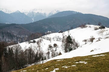 Countryside snowy winter landscape with mountains in the background