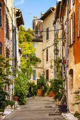 Fototapeta na wymiar Narrow streets and colorful historic houses of old town quarter with Rue de la Coste street in medieval riviera resort of Vence in France