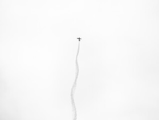 Minimalist picture with an acrobatic aircraft light airplane leaving contrails behind during Bucharest Air Show