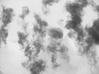 Dark smoke on white background. Dark trails of clouds in the sky.