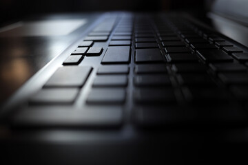 Laptop keyboard in the dark at night. The concept of an article by a journalist, work on a computer, typing