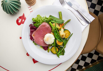 Salad with beef, grilled vegetables and poached egg