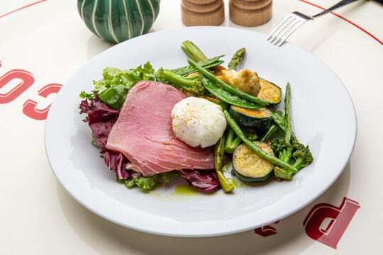 Salad with beef, grilled vegetables and poached egg