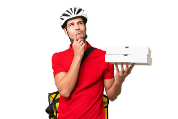 Pizza delivery man with work uniform picking up pizza boxes over isolated background having doubts...