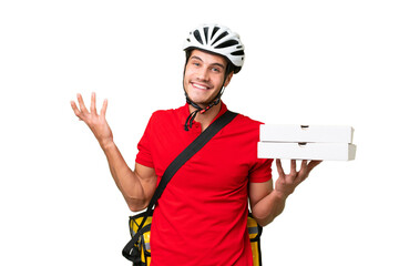 Pizza delivery man with work uniform picking up pizza boxes over isolated background extending...