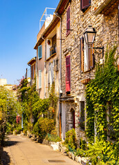 Fototapeta na wymiar Rue des Revennes street with colorful vintage houses in historic old town of Antibes resort city onshore Azure Cost of Mediterranean Sea in France