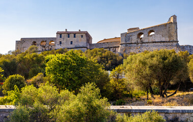 Fototapeta premium Defense walls and towers of medieval fortress Fort Carre castle in Antibes resort city onshore Azure Cost of Mediterranean Sea in France