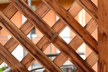 Brown wood trellis macro. pine wood privacy screen or lattice detail. narrow strips fastened with...