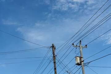 High voltage power pole against blue sky
