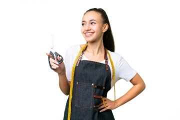 Young Seamstress woman over isolated chroma key background posing with arms at hip and smiling