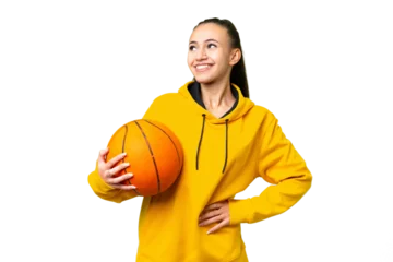 Poster Young Arabian woman playing basketball over isolated wall  over isolated chroma key background posing with arms at hip and smiling © luismolinero