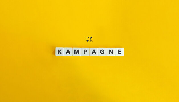 Kampagne (Word Campaign in German Language). Word and Megaphone Icon on Block Letter Tiles on Yellow Background. Minimal Aesthetics.