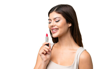 Young Russian woman with rainproof coat and umbrella over isolated chroma key background holding red lipstick