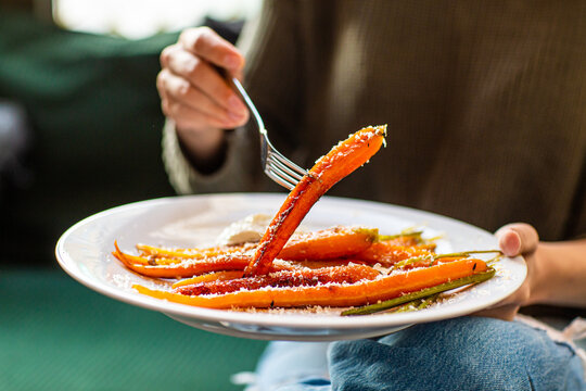 Girl holding a baked sweet potato on a fork