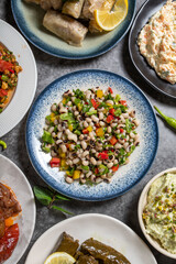 Top view traditional Turkish and Greek dinner appetizer table. Mediterranean appetizer concept. Raw meatballs, roasted eggplant salad, stuffed olives, stuffed peppers, gavurdagi salad