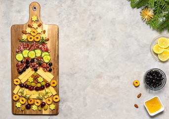 Christmas charcuterie board with different meat and cheese appetisers in shape of Christmas tree