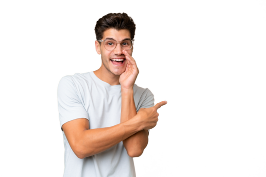 Young caucasian handsome man over isolated background pointing to the side to present a product and whispering something