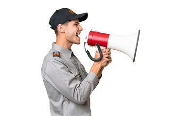 Young security man over isolated background shouting through a megaphone