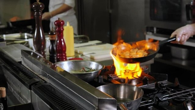 Close-up of red wine sauce burning in a saucepan in the restaurant kitchen, the process of preparing sauce for red wine meat.