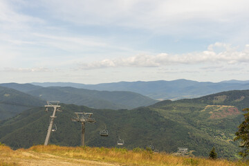 Mountain lift on a summer day over the mountains. Old ski lift in the mountains in the sun....