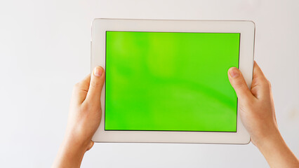 Tablet mockup in woman hands isolated in chroma key green. Close-up