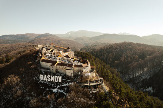 Aerial view of Rasnov fortress near Brasov, Transylvania, Romania. Rasnov Citadel and Fortress on the top of the hill in Transylvania. Drone shot of Rasnov Medieval city