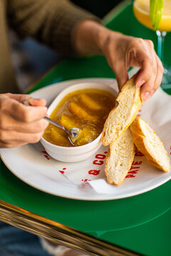 Girl smears chicken pate with a fork on bread