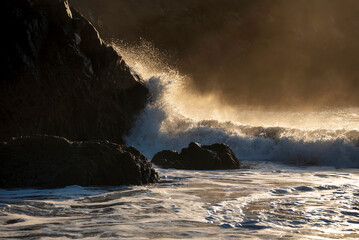 Majestic landscape image of jade turquoise waves crashing onto shore and rocks in Kynance Cove...