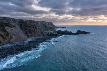 Obraz premium Gorgeous vibrant aerial drone landscape sunset image of Welcombe Mouth Beach in Devon England
