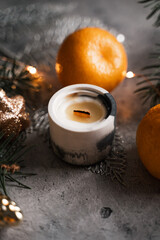 New Year's atmosphere, a candle surrounded by fir branches, tangerines and Christmas tree decorations, a colorful desktop screensaver 