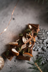 dark chocolate with handmade nuts in a New Year's atmosphere, DIY gifts, colorful background 