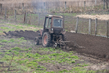 Fototapeta premium Old tractor riding in the highlands. Agriculture.