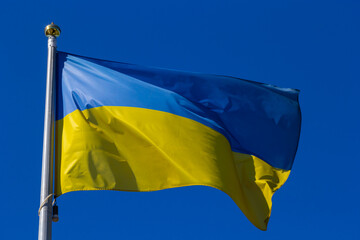 National flag of Ukraine against blue sky, The wind blows out