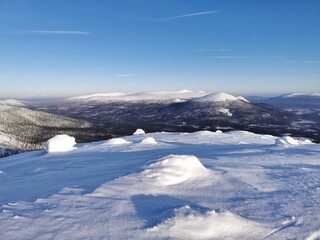 View from the hight of snowcapped mountains. Winter northern landscape with copy space. Volosyanaya mountain, Kandalaksha, Kola Peninsula, Murmansk region.