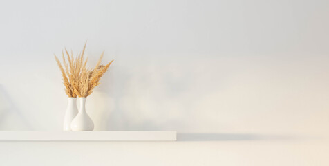 bouquet of dried wild flowers in white vase on wooden shelf on background white wall