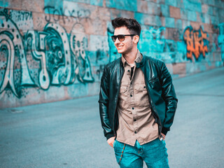Handsome young man outside smiling to camera