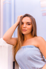 Portrait of attractive young blonde woman in blue dungarees smiling in a blue house